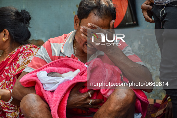 A man cries as he holds the body of his three-day-old grandson who died from respiratory problems, at a hospital in Kolkata, on March 01, 20...