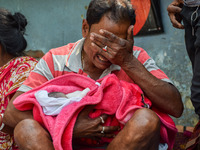 A man cries as he holds the body of his three-day-old grandson who died from respiratory problems, at a hospital in Kolkata, on March 01, 20...