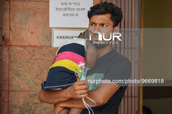 A man holds his daughter who is suffering from respiratory problems, ahead of her health check-up, at a hospital in Kolkata, on March 01, 20...