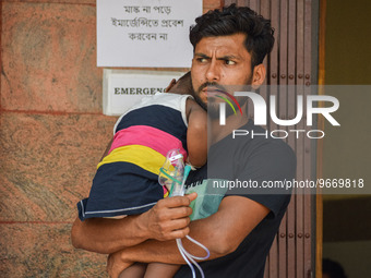 A man holds his daughter who is suffering from respiratory problems, ahead of her health check-up, at a hospital in Kolkata, on March 01, 20...