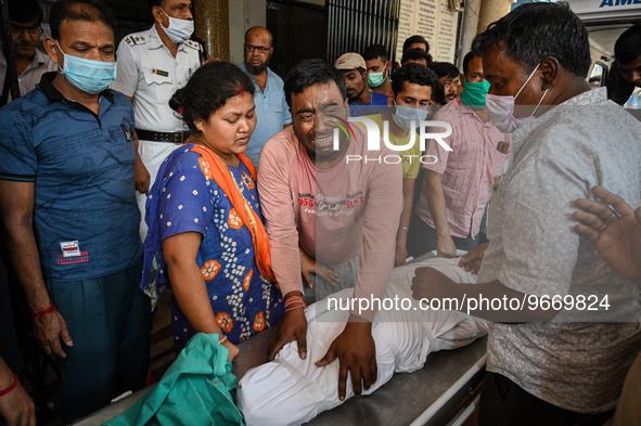 A man cries as he holds the body of his four-year-old son who died from respiratory problems, at a hospital in Kolkata, on March 01, 2023. T...