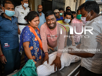 A man cries as he holds the body of his four-year-old son who died from respiratory problems, at a hospital in Kolkata, on March 01, 2023. T...