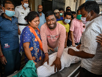 A man cries as he holds the body of his four-year-old son who died from respiratory problems, at a hospital in Kolkata, on March 01, 2023. T...