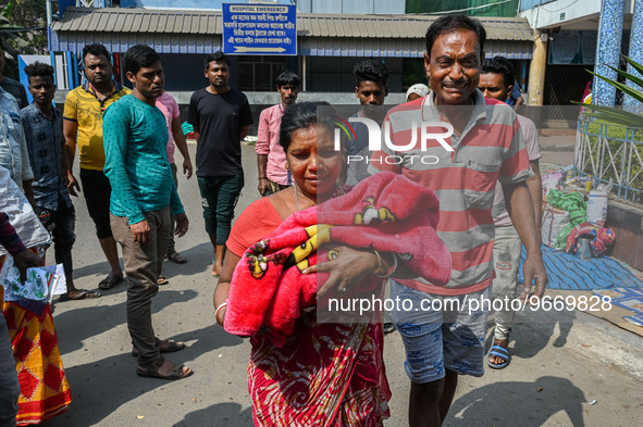 A woman cries as she holds the body of her three-day-old grandson who died from respiratory problems, at a hospital in Kolkata, on March 01,...