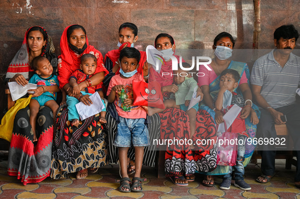 Women wait in queue as they have come for a health check-up of their children, who are suffering from fever and respiratory problems, at a h...