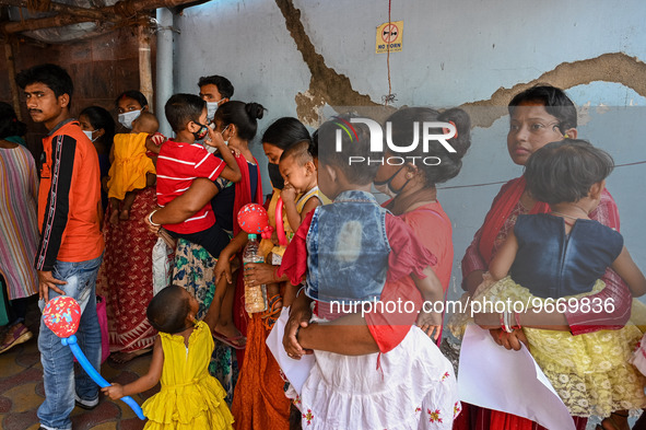 Women wait in queue as they have come for a health check-up of their children, who are suffering from fever and respiratory problems, at a h...