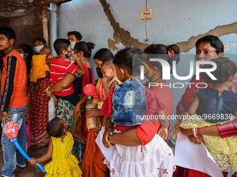 Women wait in queue as they have come for a health check-up of their children, who are suffering from fever and respiratory problems, at a h...