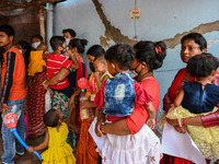 Women wait in queue as they have come for a health check-up of their children, who are suffering from fever and respiratory problems, at a h...