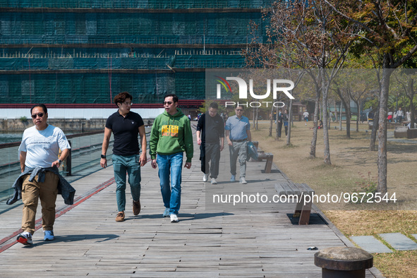 Unmasked men stroll on the Kwun Tong Promenade around noon. Today was the first day the mask mandate was abolished in Hong Kong after 950 da...