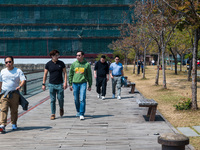 Unmasked men stroll on the Kwun Tong Promenade around noon. Today was the first day the mask mandate was abolished in Hong Kong after 950 da...