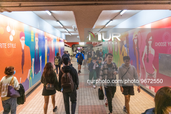 Unmasked commuters walk in a corridor leading to the MTR,in Hong Kong, China, on Mar 1, 2023. 