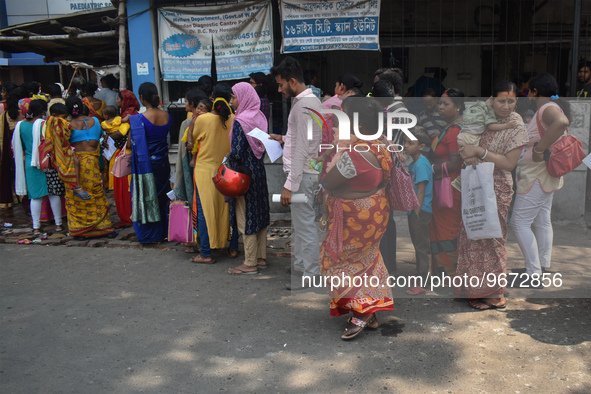 People wait in queue as they have come for a health check-up of their children, who are suffering from fever and respiratory problems, at a...