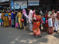 People wait in queue as they have come for a health check-up of their children, who are suffering from fever and respiratory problems, at a...