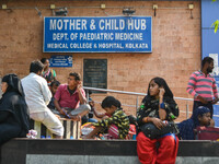 People are seen with children in front of a pediatric department at a government run hospital in Kolkata , India , on 3 March 2023 .  Kolkat...