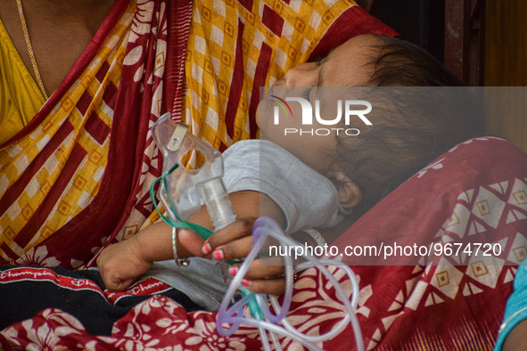 A woman holds the nebulizer mask of her child who is suffering from respiratory problems, at a hospital in Kolkata, on March 02, 2023. The e...