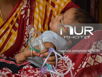 A woman holds the nebulizer mask of her child who is suffering from respiratory problems, at a hospital in Kolkata, on March 02, 2023. The e...