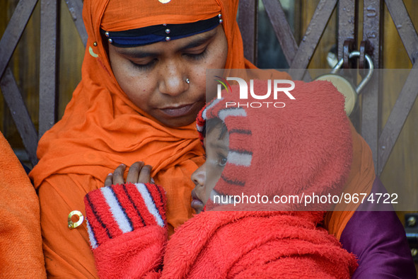 A woman holds her five-year-old daughter, who is suffering from respiratory problems, ahead of her health check-up, at a hospital in Kolkata...