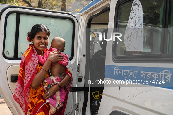 A woman reacts as she holds her three-year-old son who is suffering from respiratory problems, at a hospital in Kolkata on March 02, 2023. T...