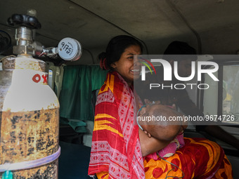 A woman reacts as she holds her three-year-old son who is suffering from respiratory problems, at a hospital in Kolkata on March 02, 2023. T...