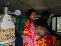 A woman reacts as she holds her three-year-old son who is suffering from respiratory problems, at a hospital in Kolkata on March 02, 2023. T...