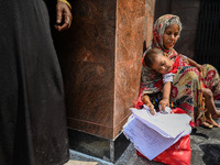 A woman sits with her grandson who is suffering from respiratory problems, at a hospital in Kolkata, on March 02, 2023. The eastern Indian s...