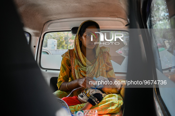 A woman holds the nebulizer mask of her child, who is suffering from respiratory problems, inside an ambulance, at a hospital in Kolkata, on...