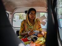 A woman holds the nebulizer mask of her child, who is suffering from respiratory problems, inside an ambulance, at a hospital in Kolkata, on...