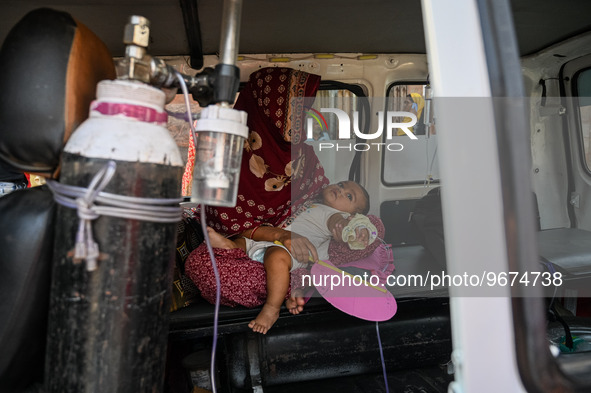 A woman sits inside an ambulance with her child, who is suffering from respiratory problems, at a hospital in Kolkata, on March 02, 2023. Th...