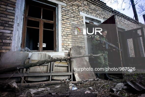 A DNR solider (formerly a traffic policeman before the war started) checks for tripwires and landmines in a destroyed building at a trolley...