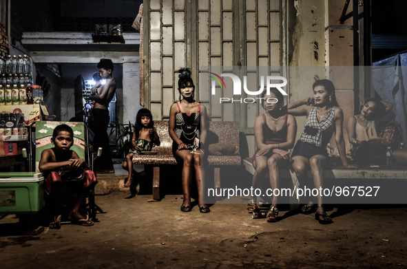 Prostitutes sit outside of a brothel on the outskirts of Siem Reap city, Cambodia on April 26, 2015. UNICEF estimates that children account...