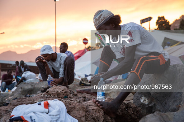 Migrants wash themselves with water bottles near the sea; in the city of Ventimiglia, on the French-Italian border, on June 23; 2015. The si...