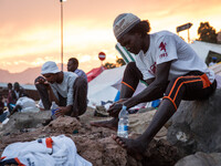 Migrants wash themselves with water bottles near the sea; in the city of Ventimiglia, on the French-Italian border, on June 23; 2015. The si...