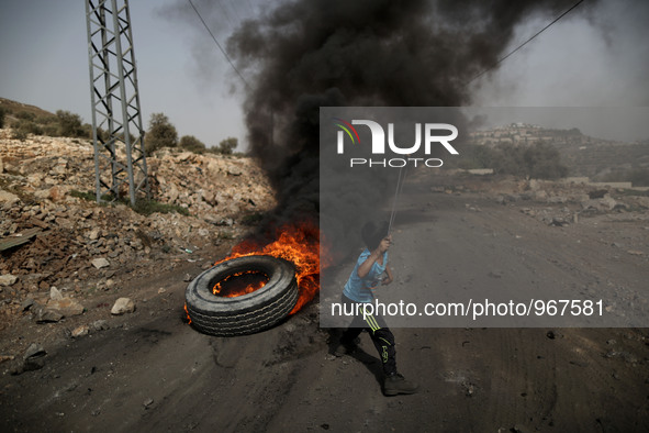 A Palestinian boy throws stones at Israeli forces during clashes with Israeli soldiers over the Jewish settlement of Qadomem at Kofr Qadom v...