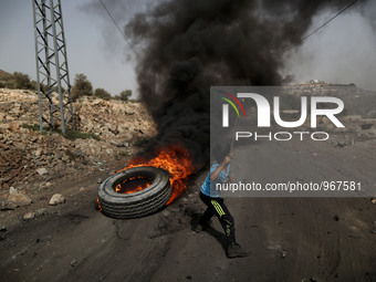 A Palestinian boy throws stones at Israeli forces during clashes with Israeli soldiers over the Jewish settlement of Qadomem at Kofr Qadom v...