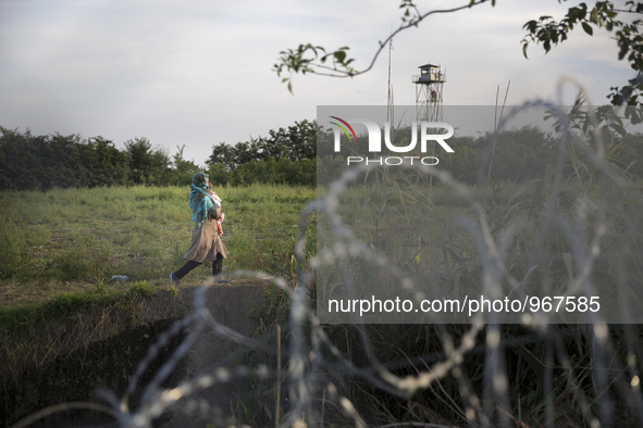 RoszRoszke,  Hungary- September 14, 2015-- Immigrants walking behind a barbed wire fence as Hungary began closing it's southern border on Mo...