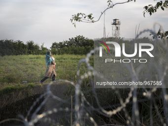 RoszRoszke,  Hungary- September 14, 2015-- Immigrants walking behind a barbed wire fence as Hungary began closing it's southern border on Mo...