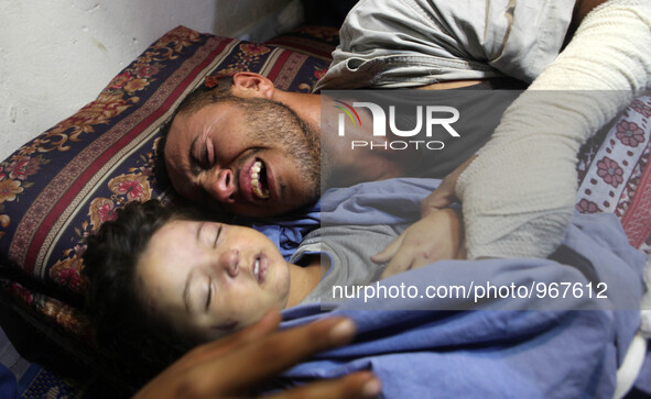 Palestinian father Yehya Hasan mourns while holding the body of his daughter, Rahaf, during a funeral for the toddler and her pregnant mothe...