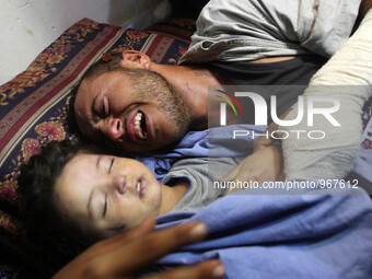 Palestinian father Yehya Hasan mourns while holding the body of his daughter, Rahaf, during a funeral for the toddler and her pregnant mothe...