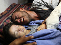 Palestinian father Yehya Hasan mourns while holding the body of his daughter, Rahaf, during a funeral for the toddler and her pregnant mothe...