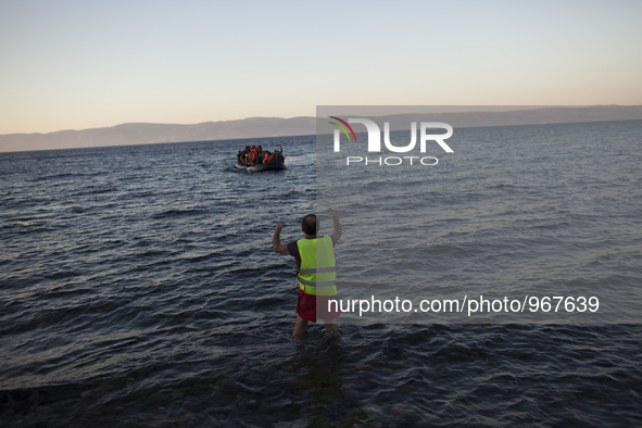 Refugees and migrants riding a dinghy reach the shores of the Greek island of Lesbos after crossing the Aegean Sea from Turkey on November 1...