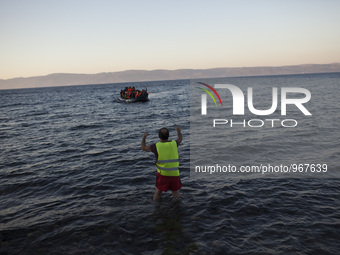 Refugees and migrants riding a dinghy reach the shores of the Greek island of Lesbos after crossing the Aegean Sea from Turkey on November 1...