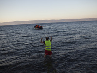 Refugees and migrants riding a dinghy reach the shores of the Greek island of Lesbos after crossing the Aegean Sea from Turkey on November 1...