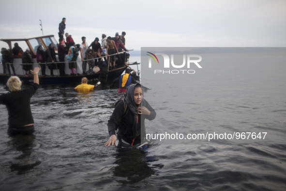 Rescuers help migrants landing on the shores of the Greek island of Lesbos after crossing the Aegean Sea from Turkey on November 16, 2015. S...