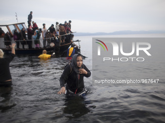 Rescuers help migrants landing on the shores of the Greek island of Lesbos after crossing the Aegean Sea from Turkey on November 16, 2015. S...