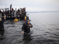 Rescuers help migrants landing on the shores of the Greek island of Lesbos after crossing the Aegean Sea from Turkey on November 16, 2015. S...