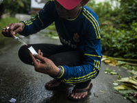 A junkies man, Dicky (33) and Hadi (42) where people live with HIV using the injection drug substitute for heroin addiction roadside in Meda...