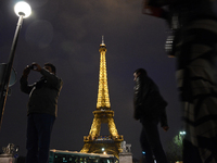 people walking in front of The Eifel Tower in Paris, France, on December 11, 2015 (