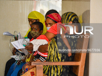 Mothers are seen in queue with their children in front of a fever clinic at a government run hospital in Kolkata , India , on 2 March 2023 ....