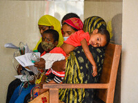 Mothers are seen in queue with their children in front of a fever clinic at a government run hospital in Kolkata , India , on 2 March 2023 ....