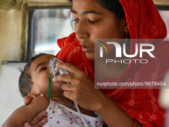 

A mother is holding an oxygen mask on the face of her child, who is suffering from respiratory distress, as seen in front of the emergency...